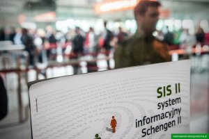 Zdjęcie przedstawia plakat Systemu Informatycznego Schengen II na tle pasażerów Lotniska Chopina/zdjęcie poglądowe/archiwum NwOSG 