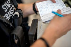 Notatnik służbowy w rękach funkcjonariusza SG 
