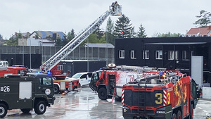 W górze strażacy stoją w koszu na wysięgniku.U dołu pojazdy gaśnicze. W górze strażacy stoją w koszu na wysięgniku.U dołu pojazdy gaśnicze.