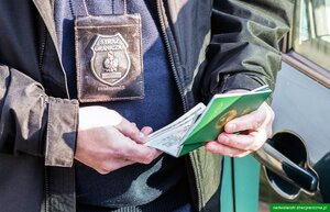 Funkcjonariusz trzyma w rękach paszporty. Funkcjonariusz trzyma w rękach paszporty.
