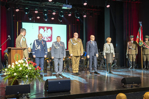 Wyróżnieni stoją na scenie w tle godło Polski. Wyróżnieni stoją na scenie w tle godło Polski.