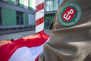 Funkcjonariusz Nadwiślańskiego Oddziału Straży Granicznej trzyma Flagę Polski. Funkcjonariusz Nadwiślańskiego Oddziału Straży Granicznej trzyma Flagę Polski.