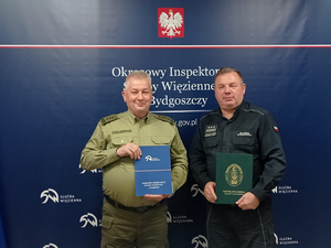 Płk SG Dariusz Lutyński i płk Andrzej Gniot pozują z podpisanym porozumieniem. Płk SG Dariusz Lutyński i płk Andrzej Gniot pozują z podpisanym porozumieniem.