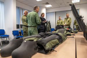 Na pierwszym planie na stole leży kombinezon pirotechniczny. W tle stoi Wojewoda i funkcjonariusze. Na pierwszym planie na stole leży kombinezon pirotechniczny. W tle stoi Wojewoda i funkcjonariusze.