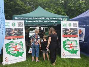 Zwiedzający stoją przed namiotem promocyjnym Straży Granicznej. Zwiedzający stoją przed namiotem promocyjnym Straży Granicznej.