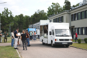 Przy samochodach food truck stoją cudzoziemcy. Przy samochodach food truck stoją cudzoziemcy.