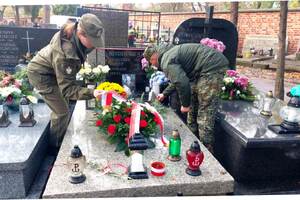 Funkcjonariusze porządkują grób. Funkcjonariusze porządkują grób.