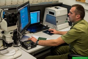 Funkcjonariusz bada autentyczność dokumentów. Funkcjonariusz bada autentyczność dokumentów.