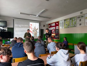 Funkcjonariusz prowadzi zajęcia z uczniami w sali lekcyjnej. Funkcjonariusz prowadzi zajęcia z uczniami w sali lekcyjnej.