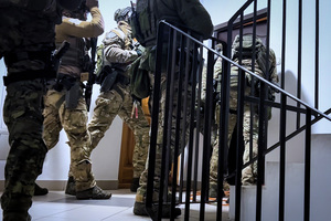 Funkcjonariusze wyważają drzwi do mieszkania. Funkcjonariusze wyważają drzwi do mieszkania.