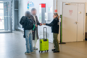Funkcjonariuszka kontroluje dokumenty podróżnych. Funkcjonariuszka kontroluje dokumenty podróżnych.