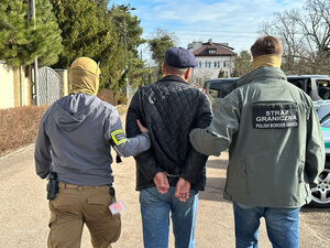 Funkcjonariusze prowadzą cudzoziemca. Funkcjonariusze prowadzą cudzoziemca.