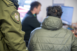 Funkcjonariusze prowadzą czynności z cudzoziemcem. Funkcjonariusze prowadzą czynności z cudzoziemcem.