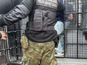 Funkcjonariusz wprowadza mężczyznę do pojazdu służbowego. Funkcjonariusz wprowadza mężczyznę do pojazdu służbowego.