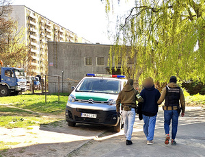 Funkcjonariusze prowadzą cudzoziemca. Funkcjonariusze prowadzą cudzoziemca.