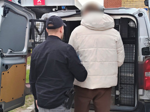 Funkcjonariusze prowadzą zatrzymanych. Funkcjonariusze prowadzą zatrzymanych.
