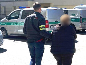 Funkcjonariusz prowadzi cudzoziemkę. Funkcjonariusz prowadzi cudzoziemkę.